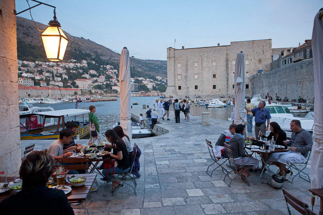 People at restaurant overlooking old harbour in Dubrovnik, Croatia, 