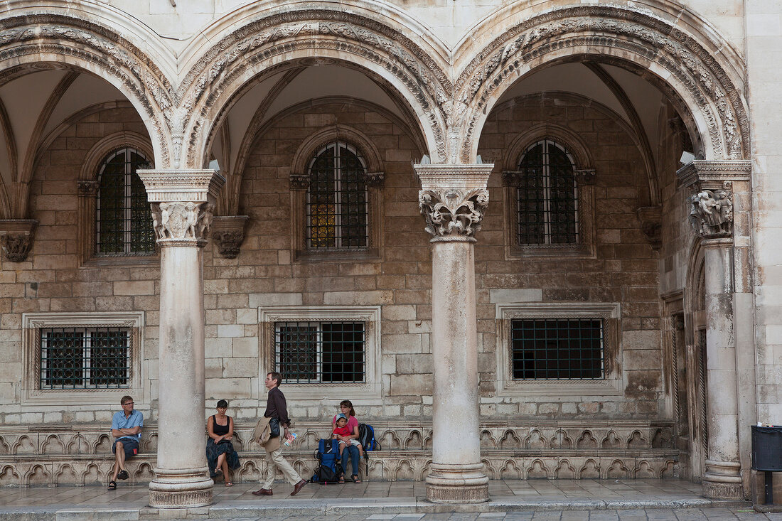 People sitting in old town arcade, Dubrovnik, Croatia