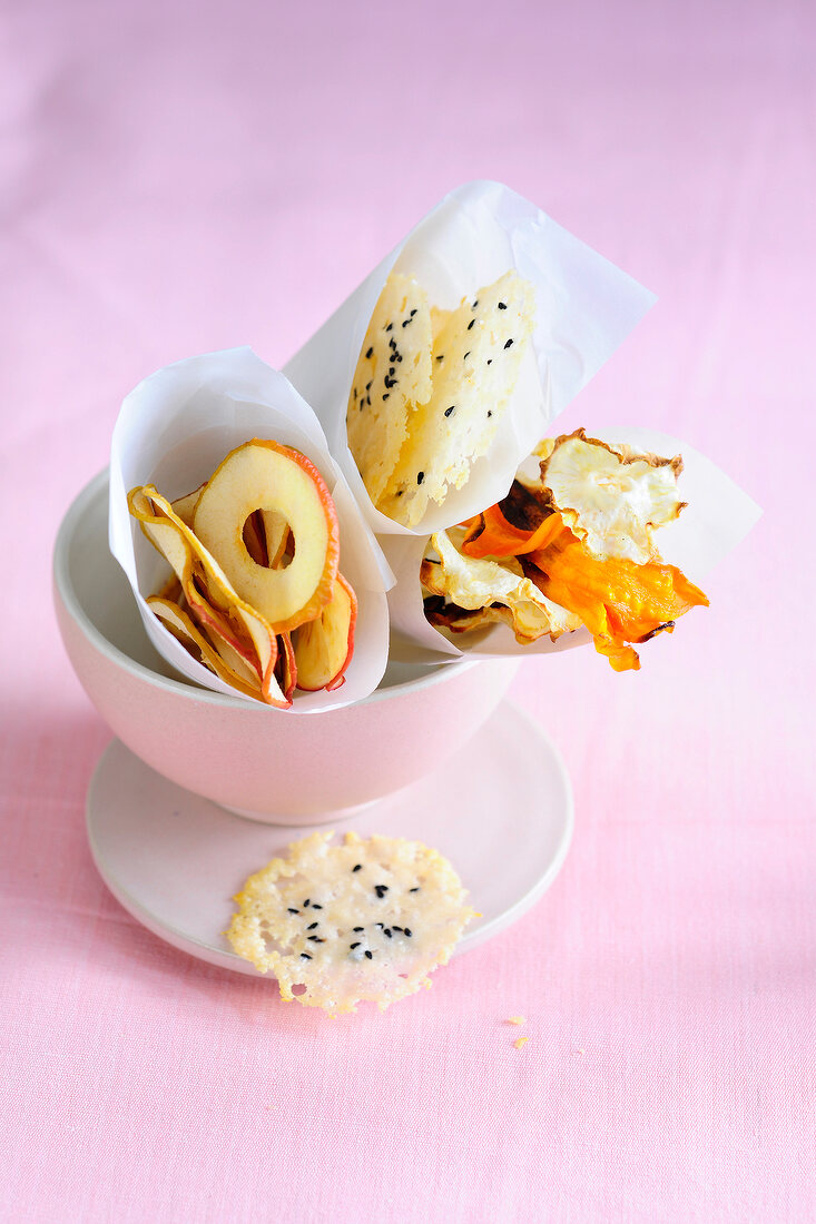 Vegetable chips, apple chips and parmesan taler in bowl, low GI diet food
