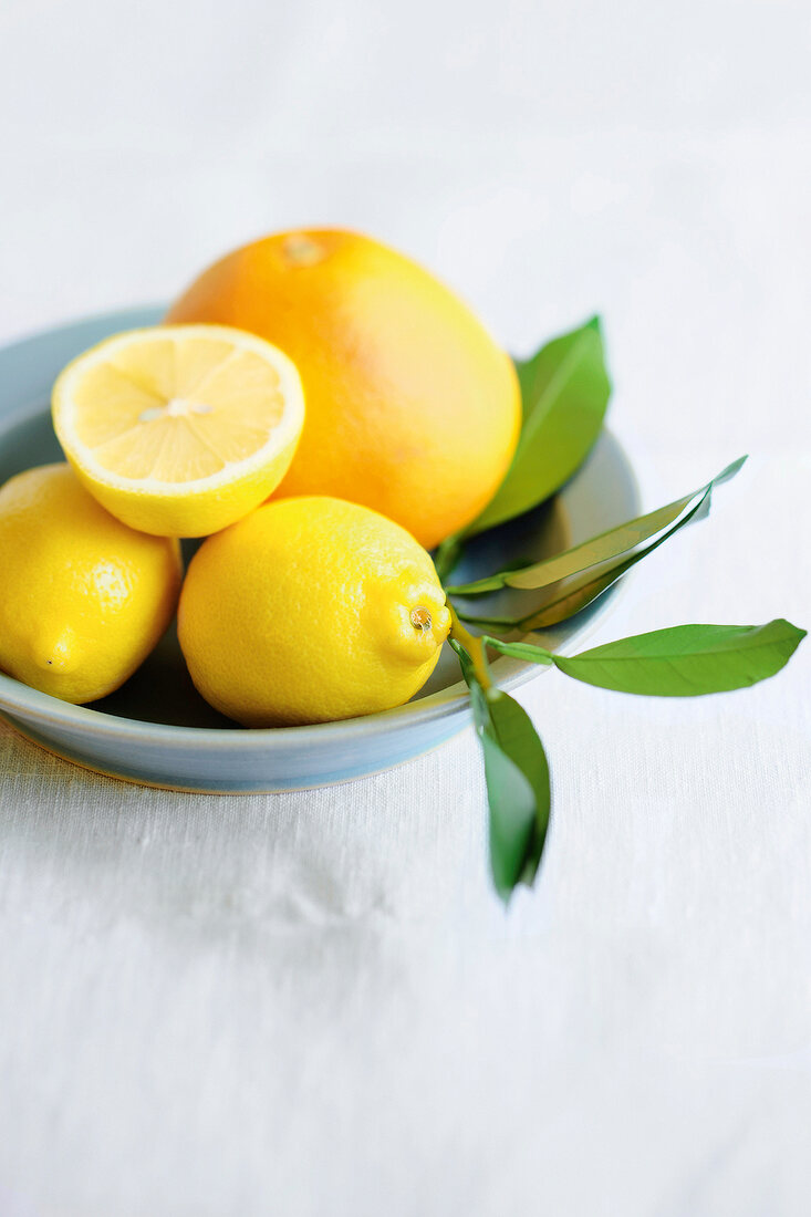 Whole and halved lemons on plate