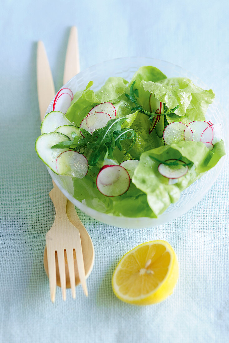 Salad in bowl beside halved lemon