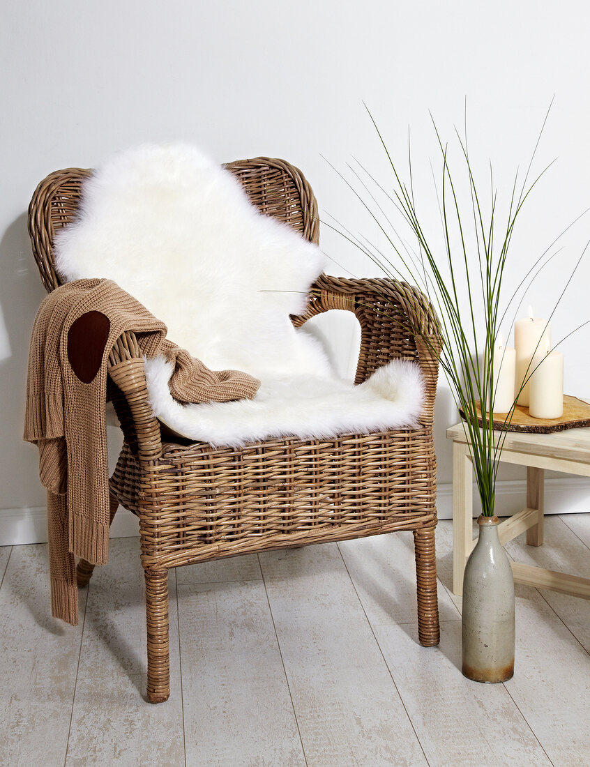 Wattle chair with sheepskin blanket on wooden floor