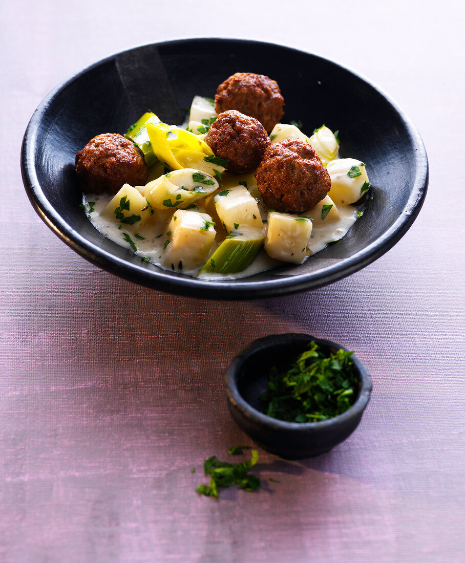 Celery and quince stew with lamb meatballs in bowl