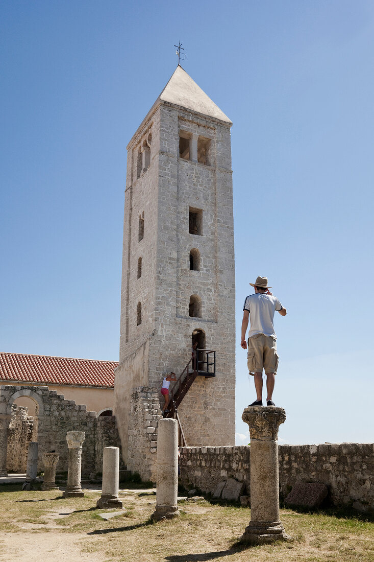 Man standing on pillar in front of Benedictine monastery, Kvarner, Croatia