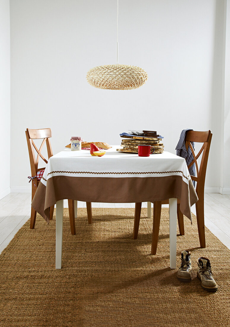 Dining table with chairs, brown carpet and hanging lamp