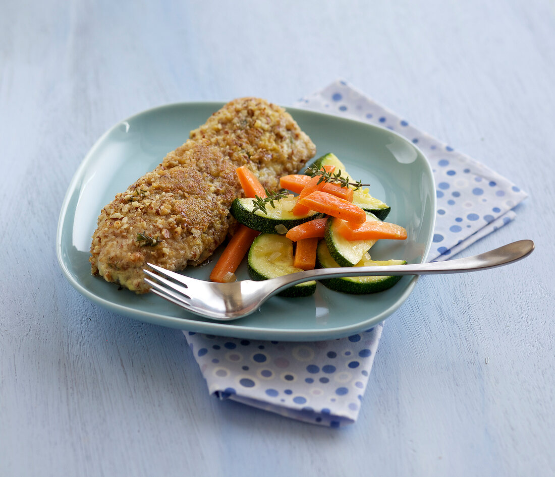 Crispy fish with courgettes on plate