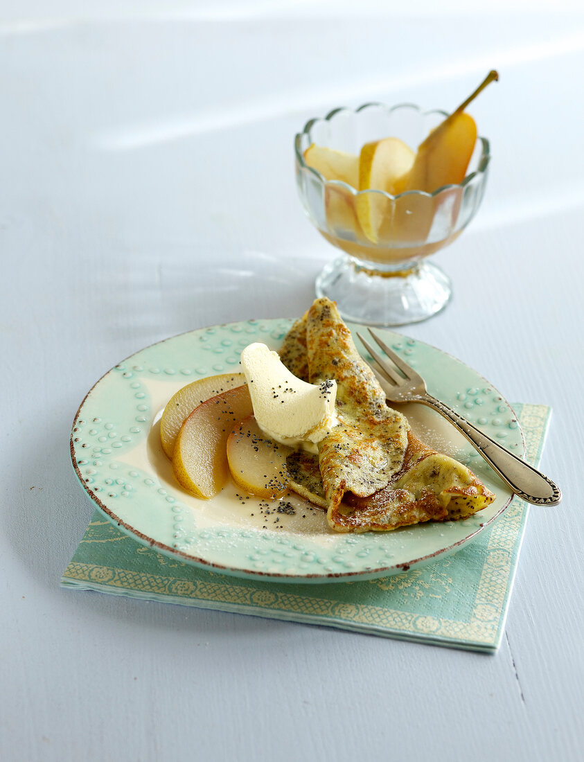 Poppy pancakes with pears on plate
