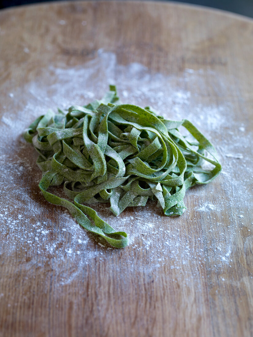 Green noodles on wooden board