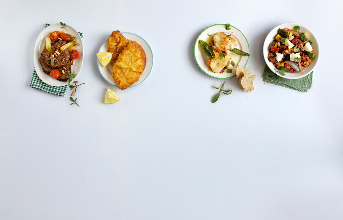 Four varieties of meat dishes on white background