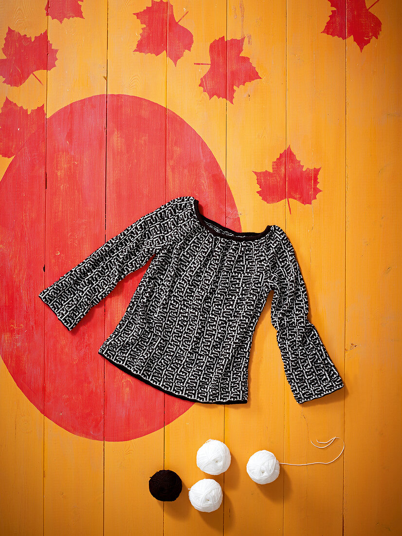 Black and white knitted sweater on patterned background