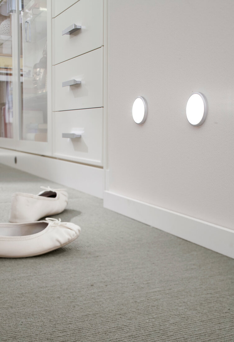 Close-up of wall lights with shoes on side