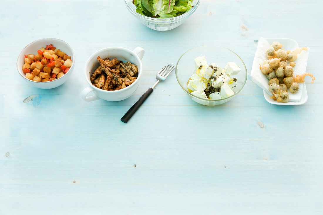 Various salad toppings in bowls and on plate