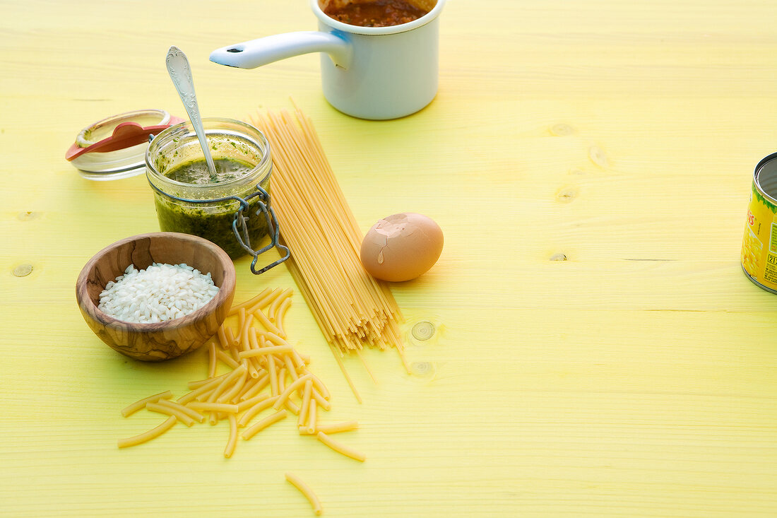 Rice in bowl and jar of pesto with spoon