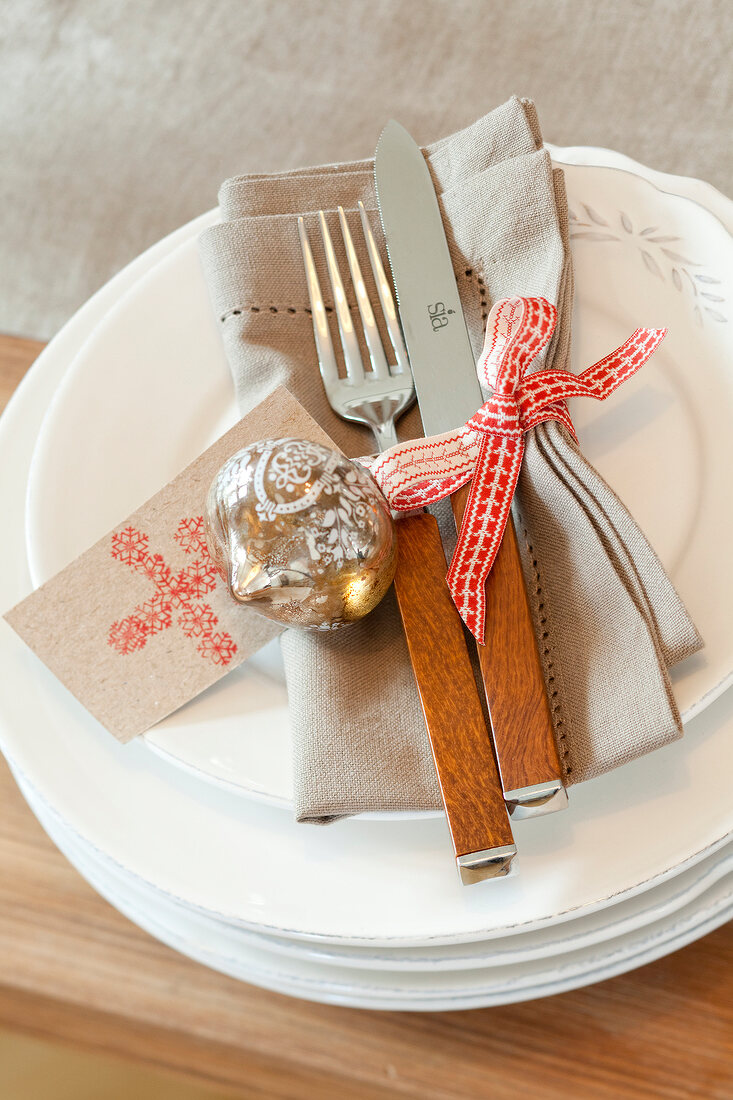 Cutlery, napkin and bauble on plate