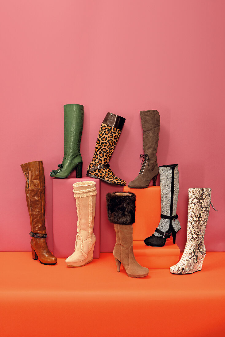 Various boots against pink and orange background
