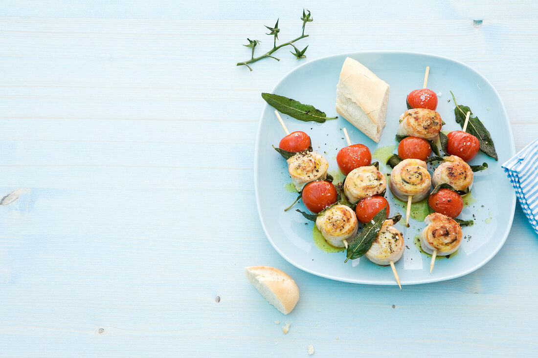 Turkey kebabs skewered with tomatoes and sage on plate