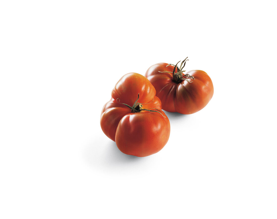 Two ox tomatoes on white background