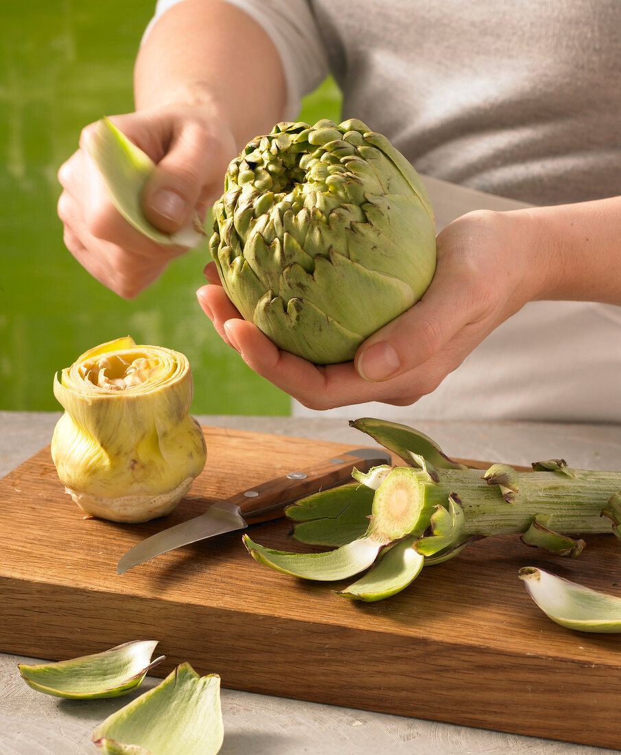 Close-up of hand cleaning artichokes