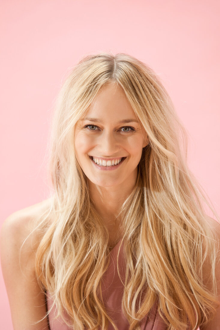 Portrait of beautiful gray eyed woman with long blonde hair, smiling