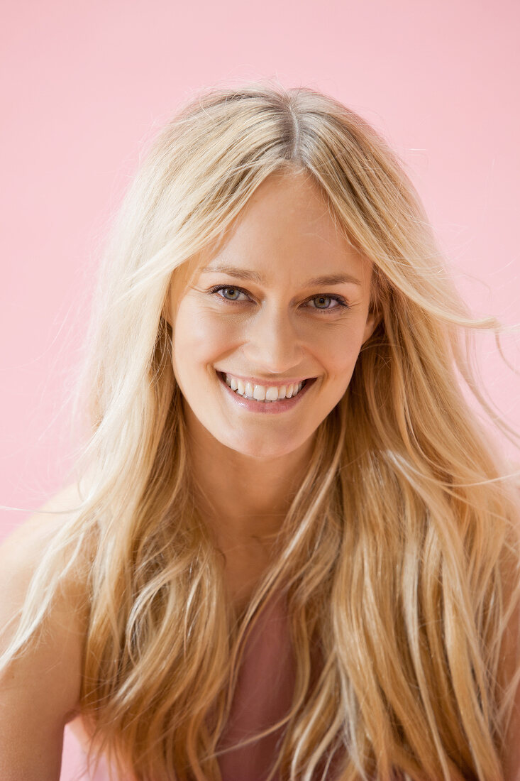 Portrait of beautiful gray eyed woman with long blonde hair, smiling widely