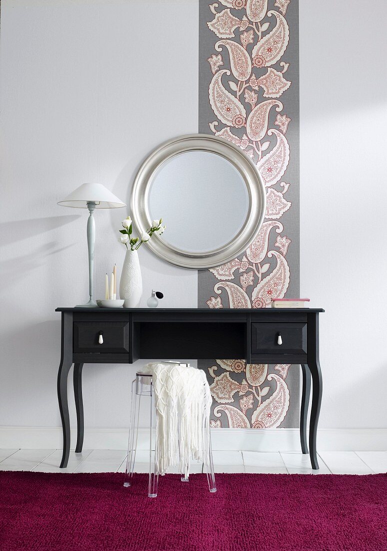 Black dressing table against wallpaper with paisley pattern