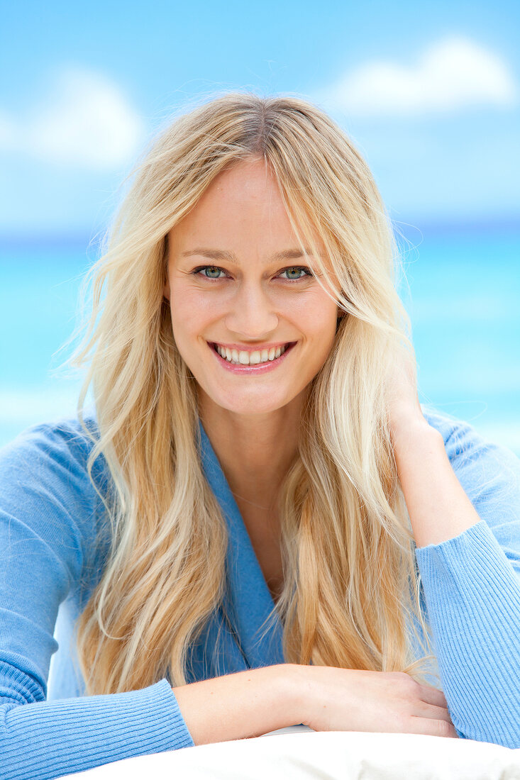 Portrait of beautiful blonde woman wearing blue sweater, smiling