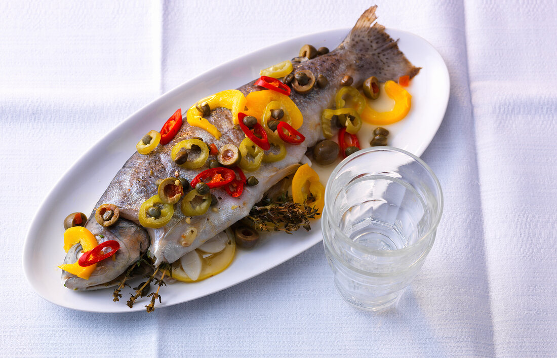 Trout fish garnished with pepper on serving tray