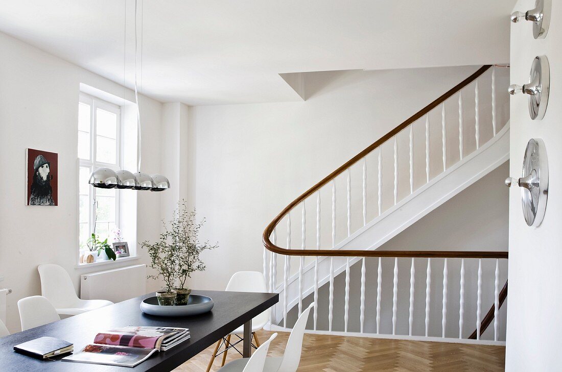 A living room with a dining table next to a staircase