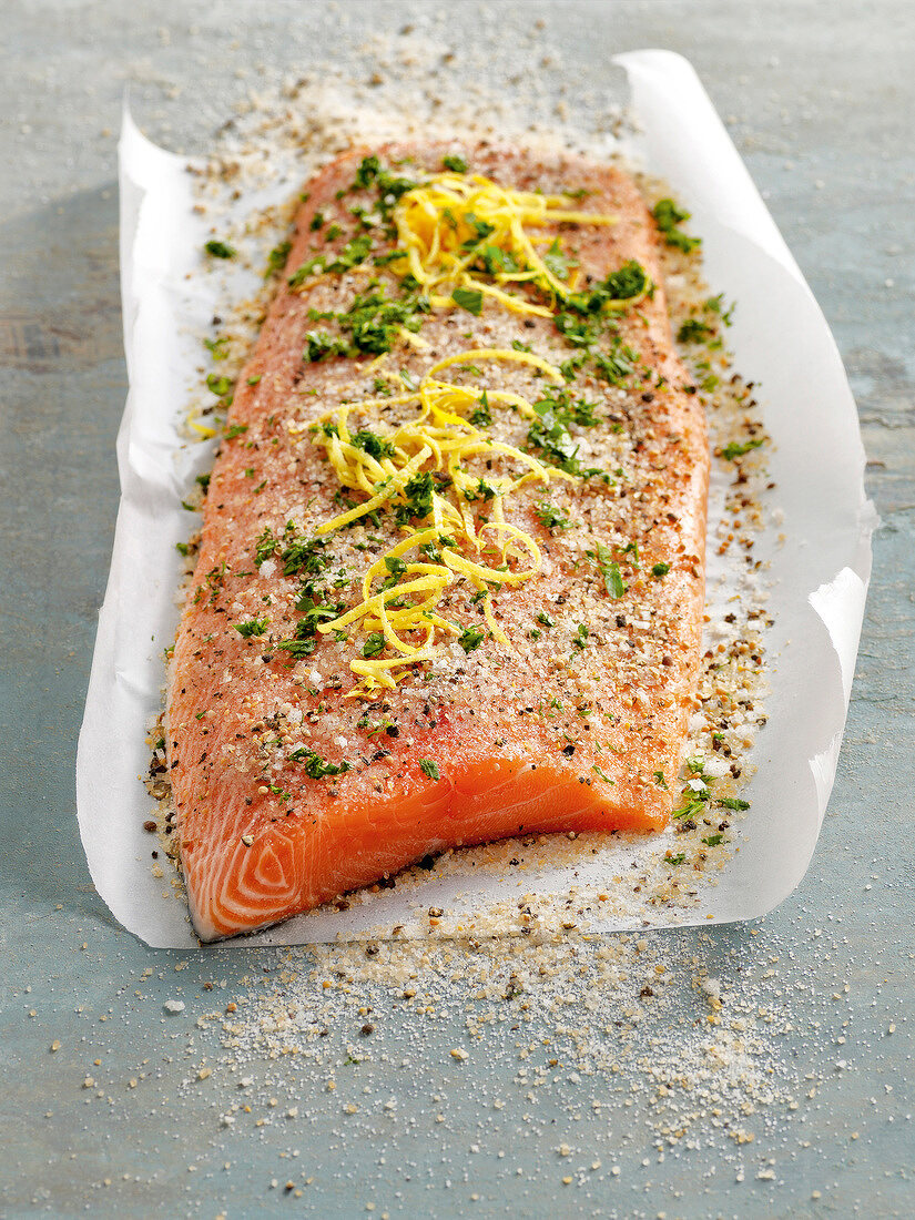 Close-up of marinated salmon with herbs on paper for winter