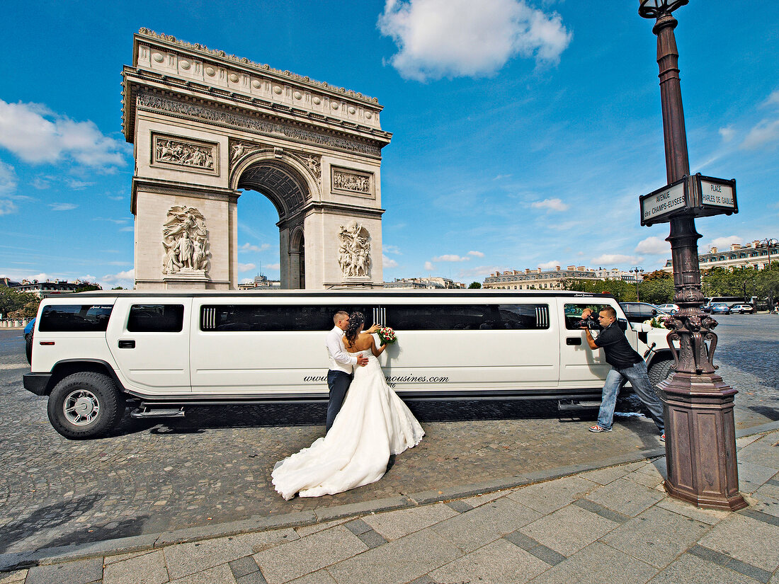 Wedding couple standing near car in Arc de Triomphe, Place Charles de Gaulle, Paris