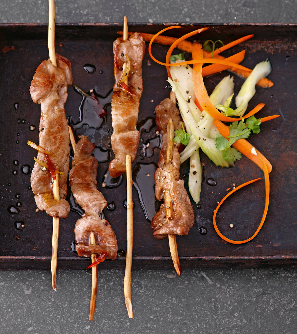 Close-up of pork skewers in marshala on tray