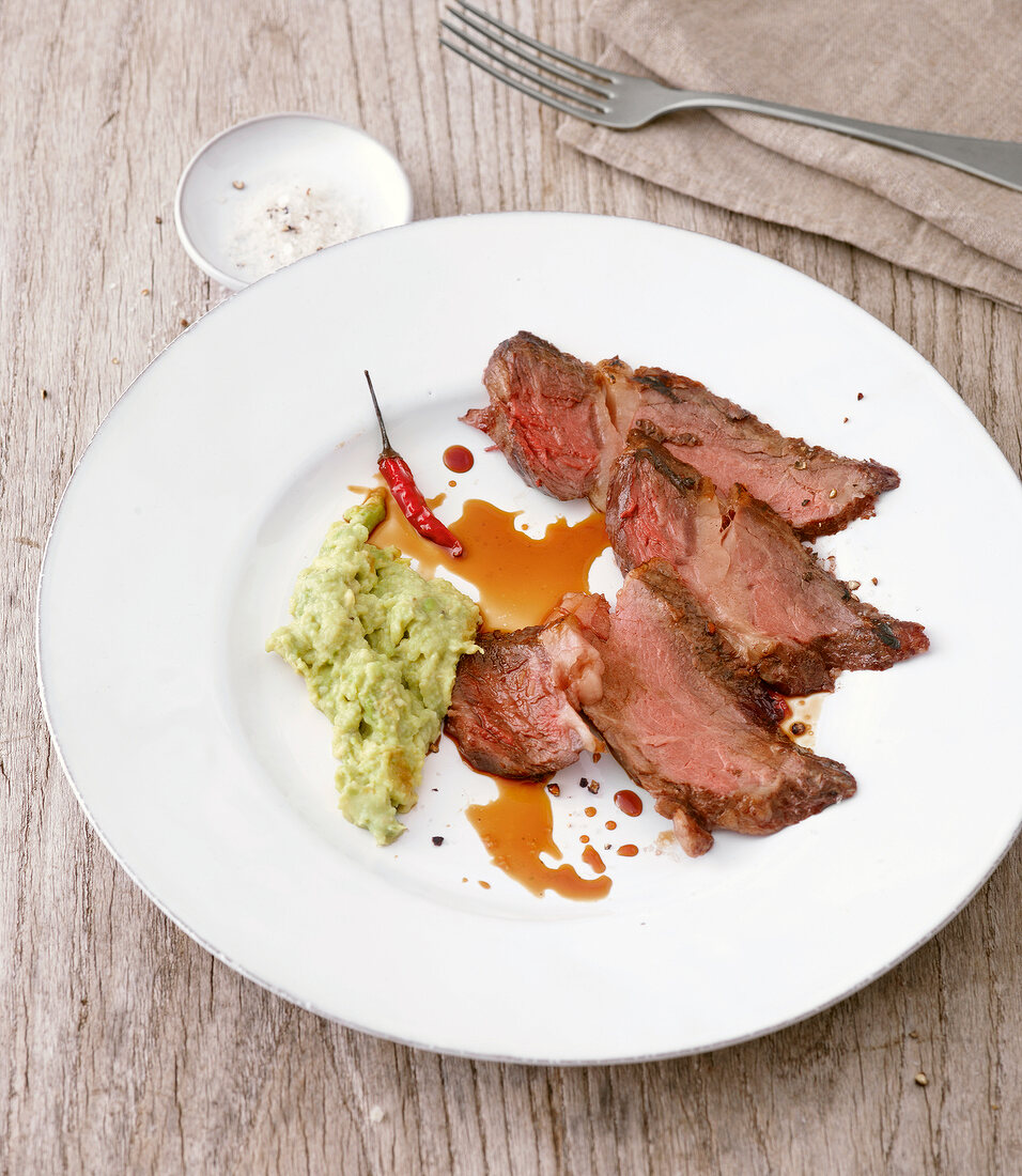 Sirloin steak with coffee marinade and avocado dip on plate