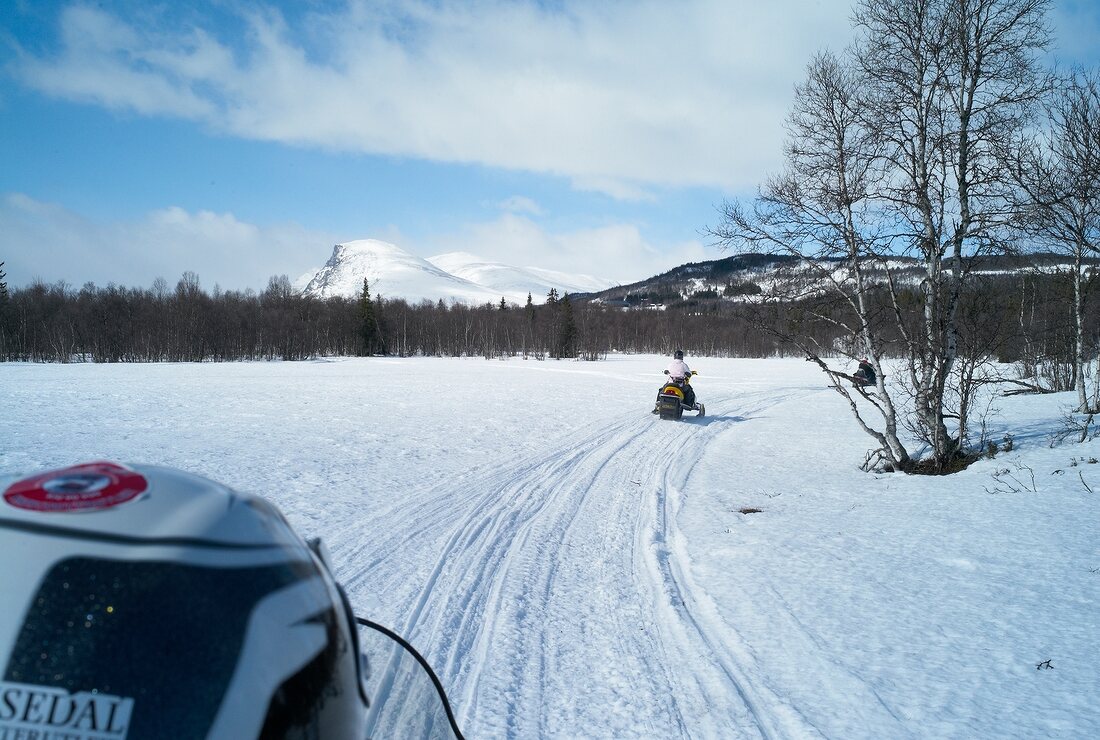People riding snow mobile on snow at Hemsedal ski resort in Norway