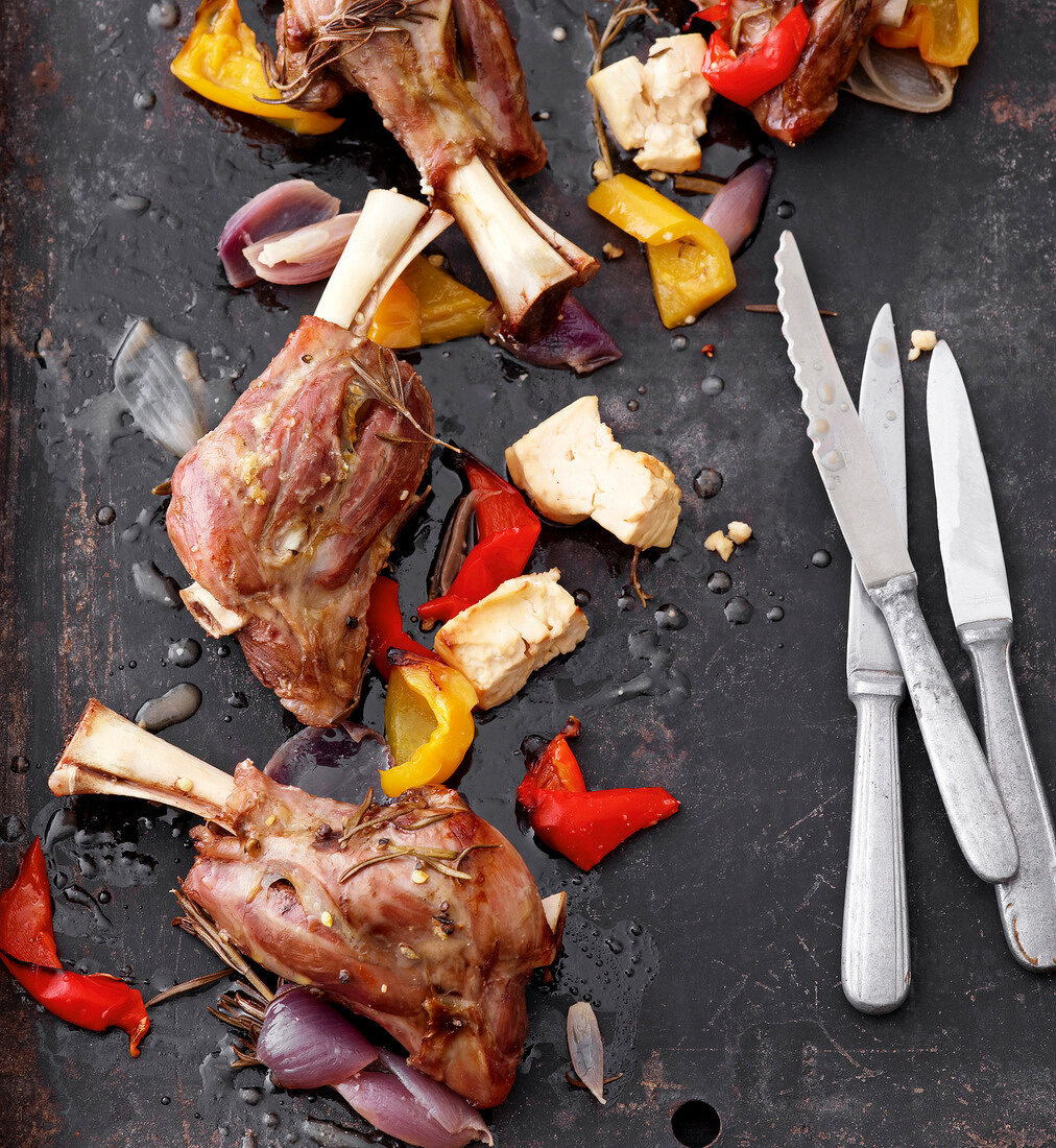 Close-up of roasted lamb shanks with vegetables on pan