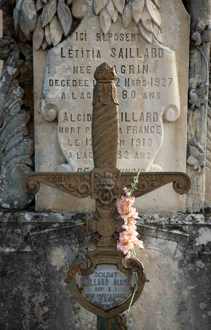 Close-up of grave stone and cross in cemetery, France