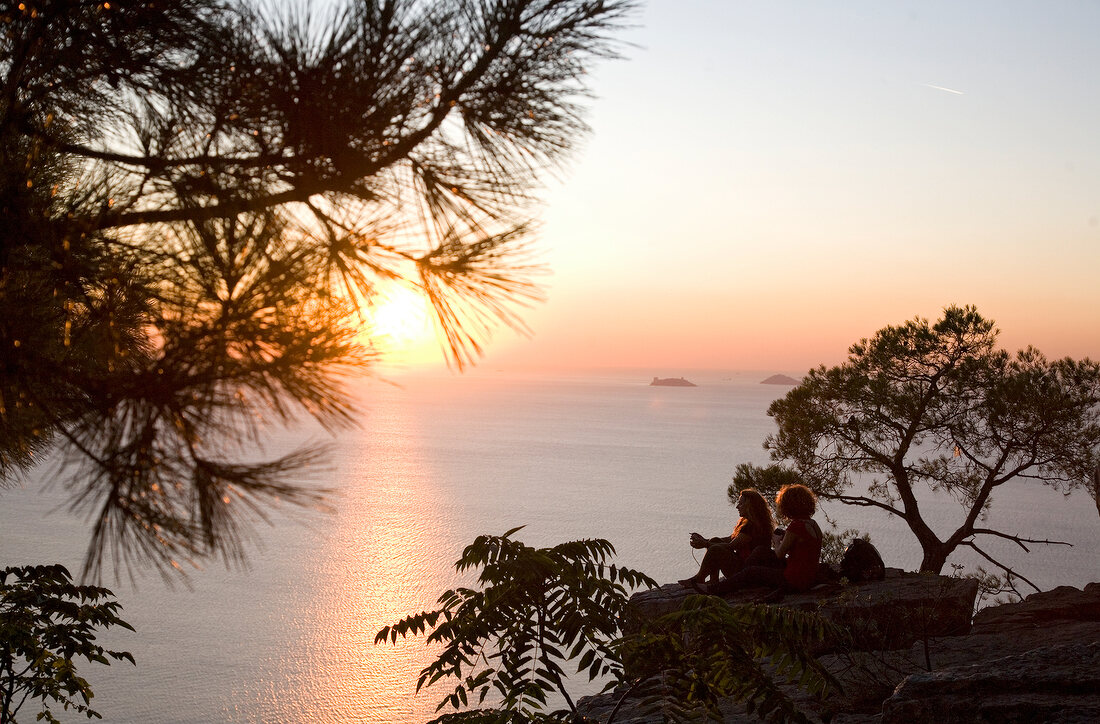 Couple sitting on cliff in front of Marmara sea, Prince island, Istanbul, Turkey