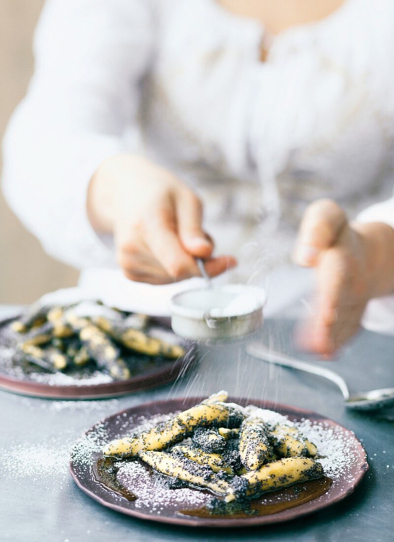 Handmade poppyseed pasta being dusted with icing sugar