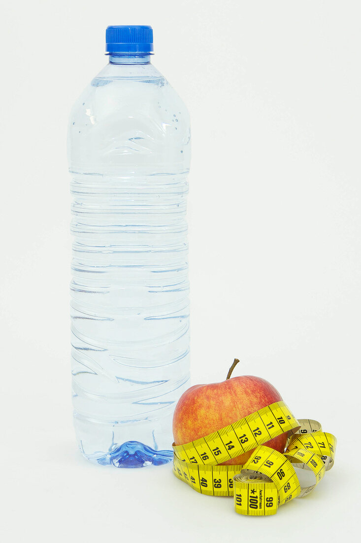 Symbolbild für Diät, Apfel mit Maßband und Flasche Wasser