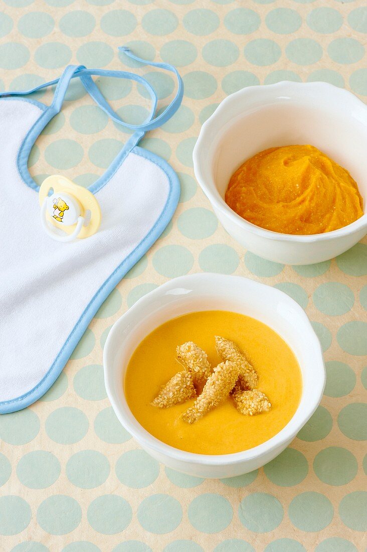 A bowl of baby food and a bowl of carrot soup with ginger