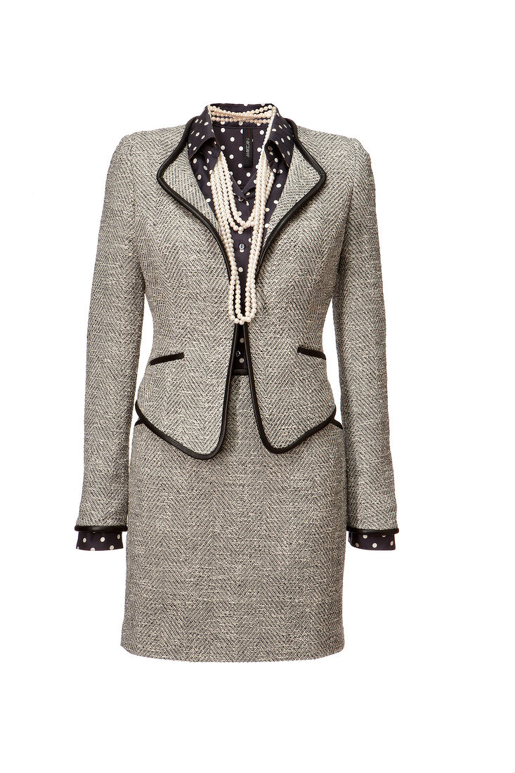 Tweed blazer, skirt with polka dotted shirt and necklace on white background