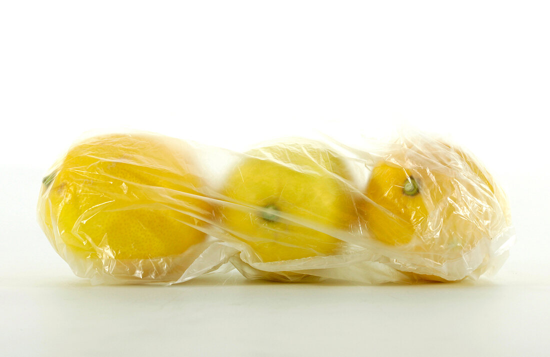 Whole lemons in foil bag on white background