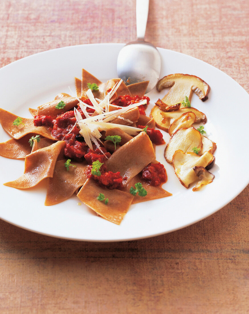 Maltagliati pasta with porcini sausage and mushroom on plate