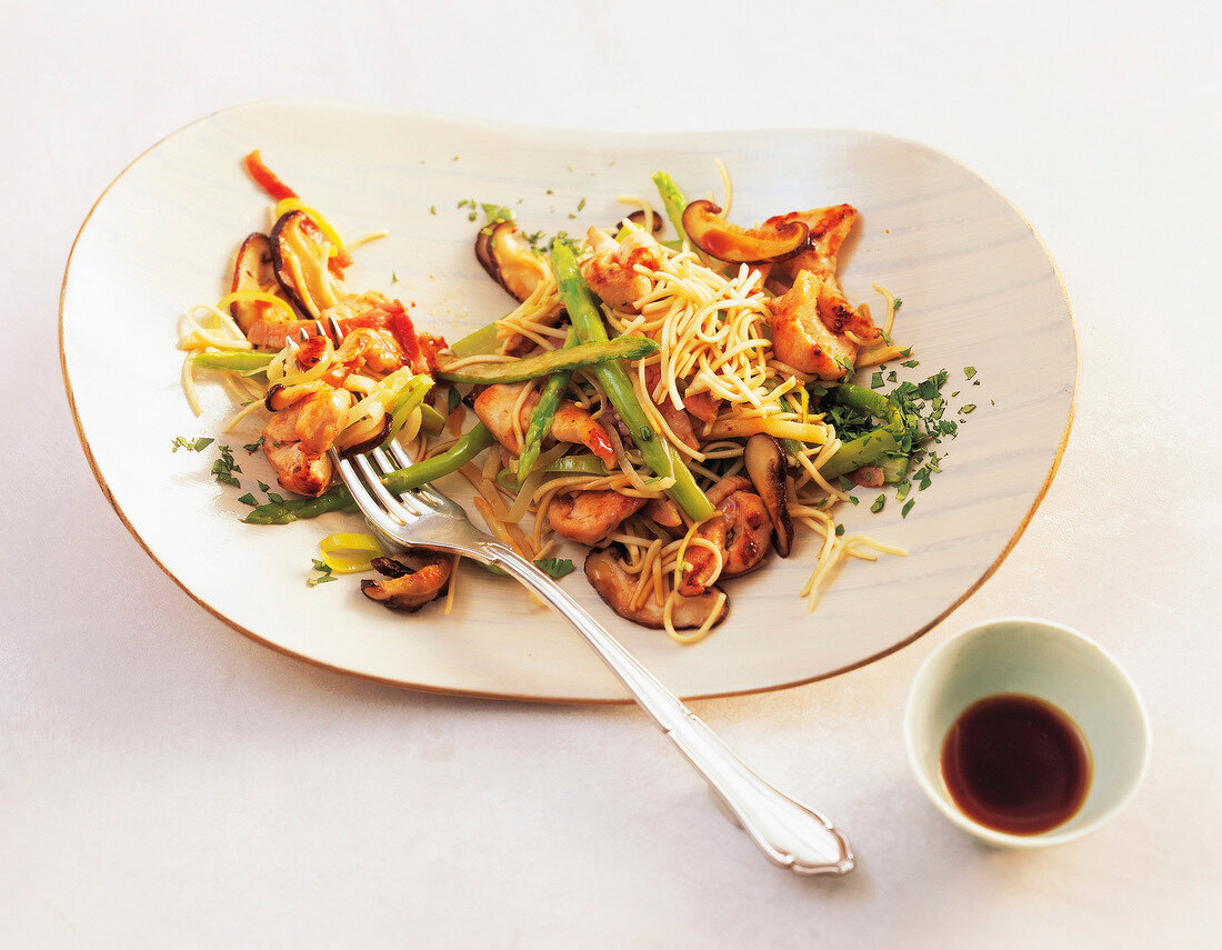 Pasta noodles with chicken and green asparagus on plate