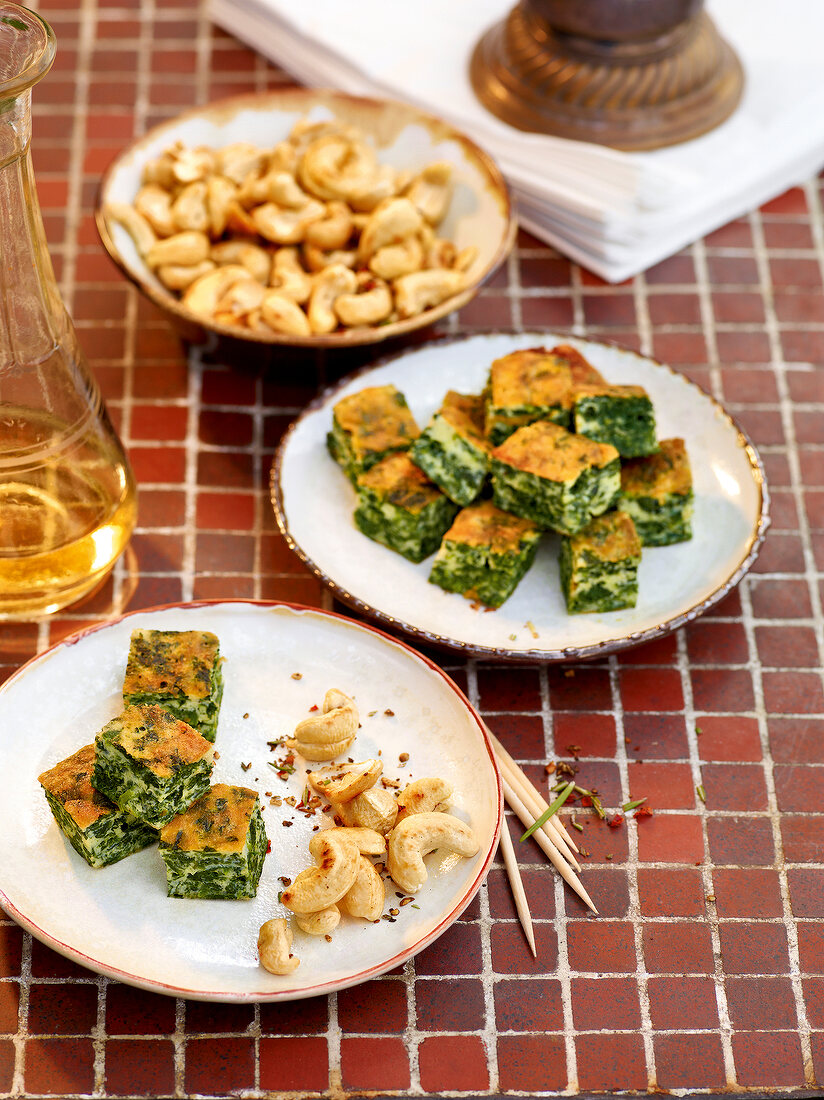 Pieces of omelettes with spinach and toasted walnuts on plates