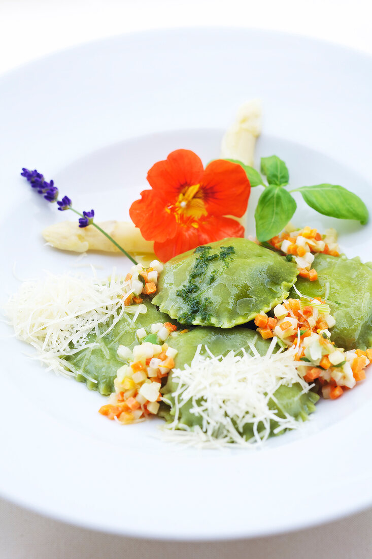 Close-up of ravioli with cheese, apple sauce and wild garlic in serving dish