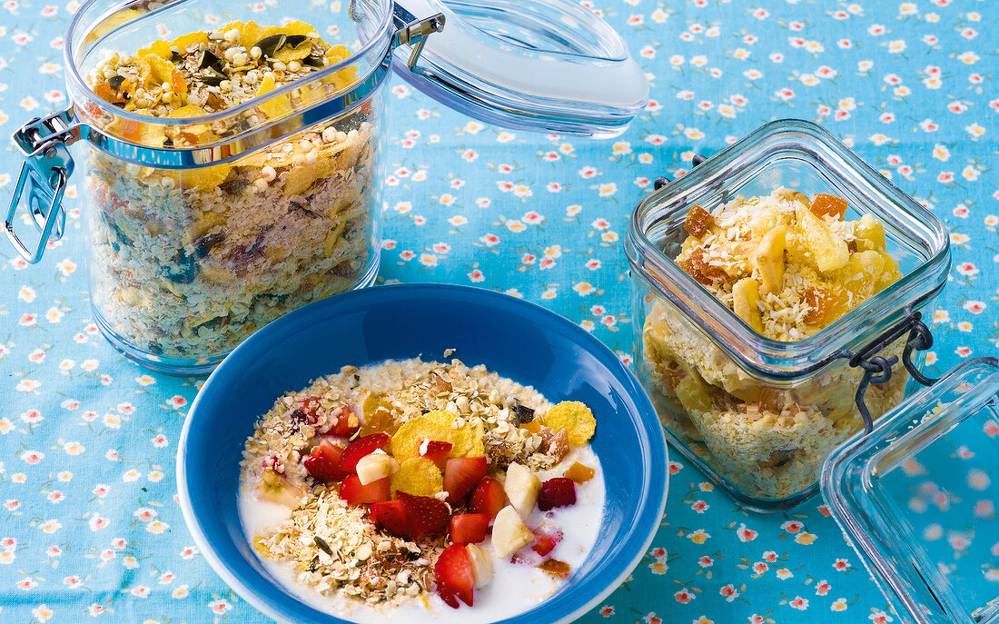 Three different kinds of cereal for infants in bowl and glass jars