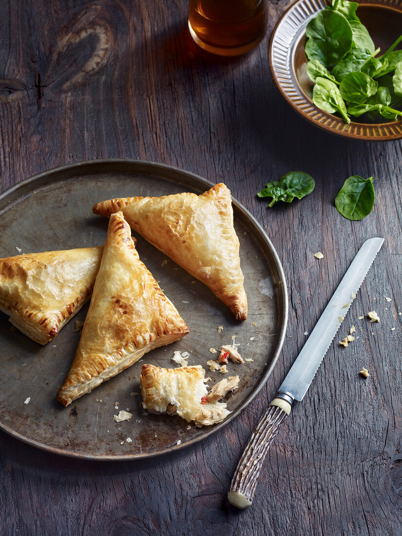 Close-up of puff pastry bag on plate with knife