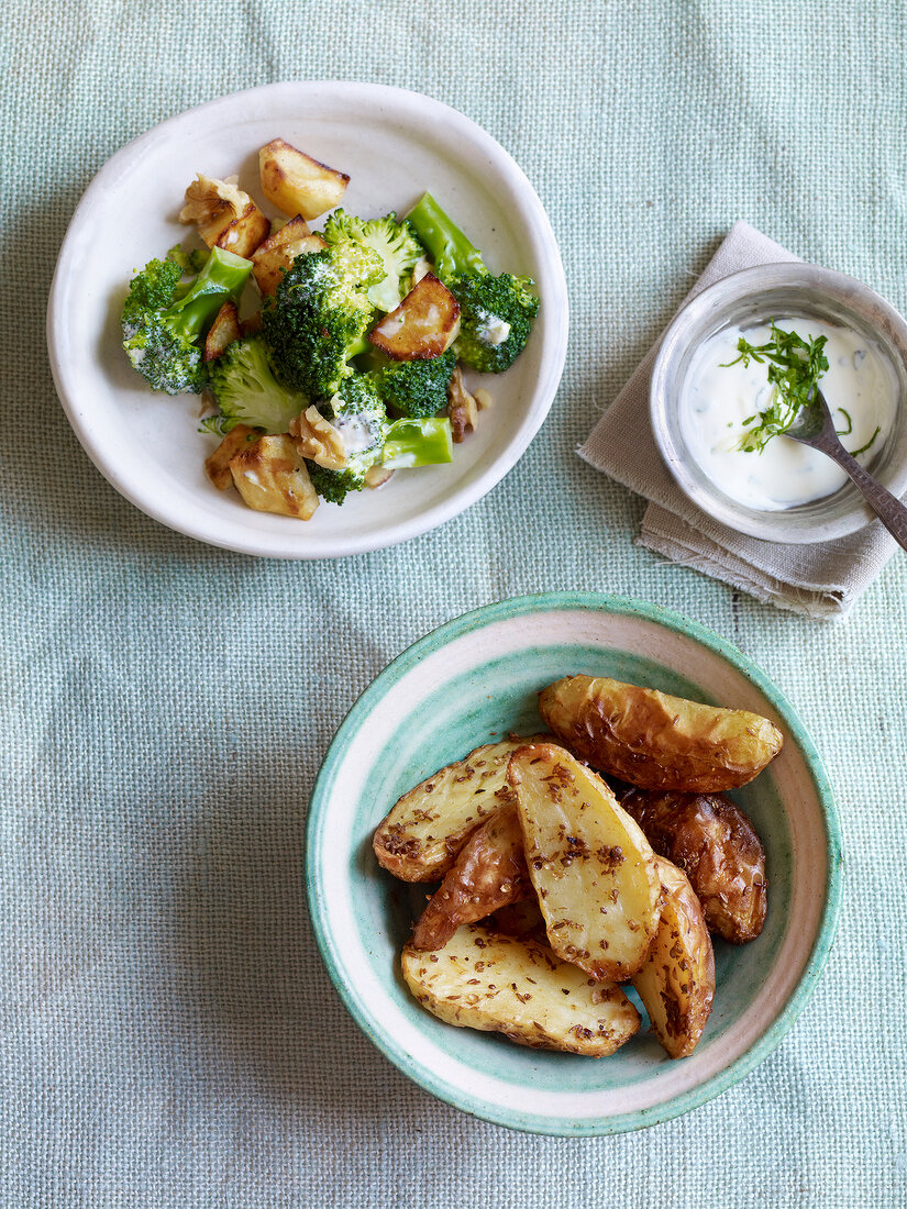 Broccoli with walnuts and spice potatoes with dip in serving dish