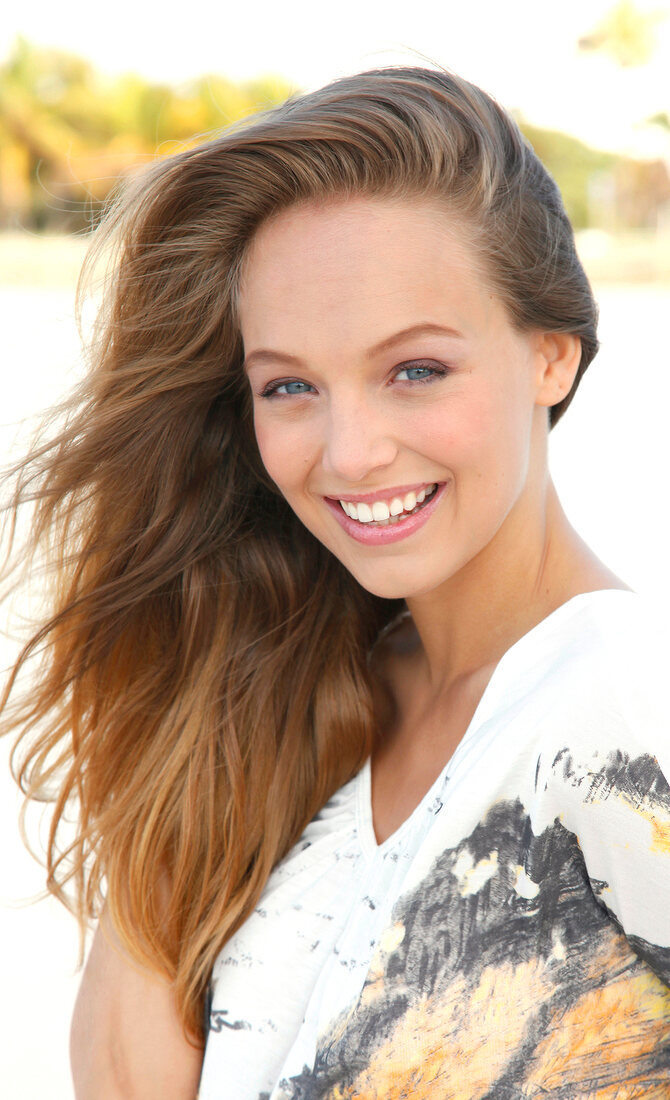 Portrait of beautiful woman wearing white patterned top, smiling