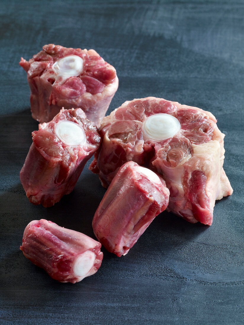 Close-up of pieces of raw veal leg on gray surface